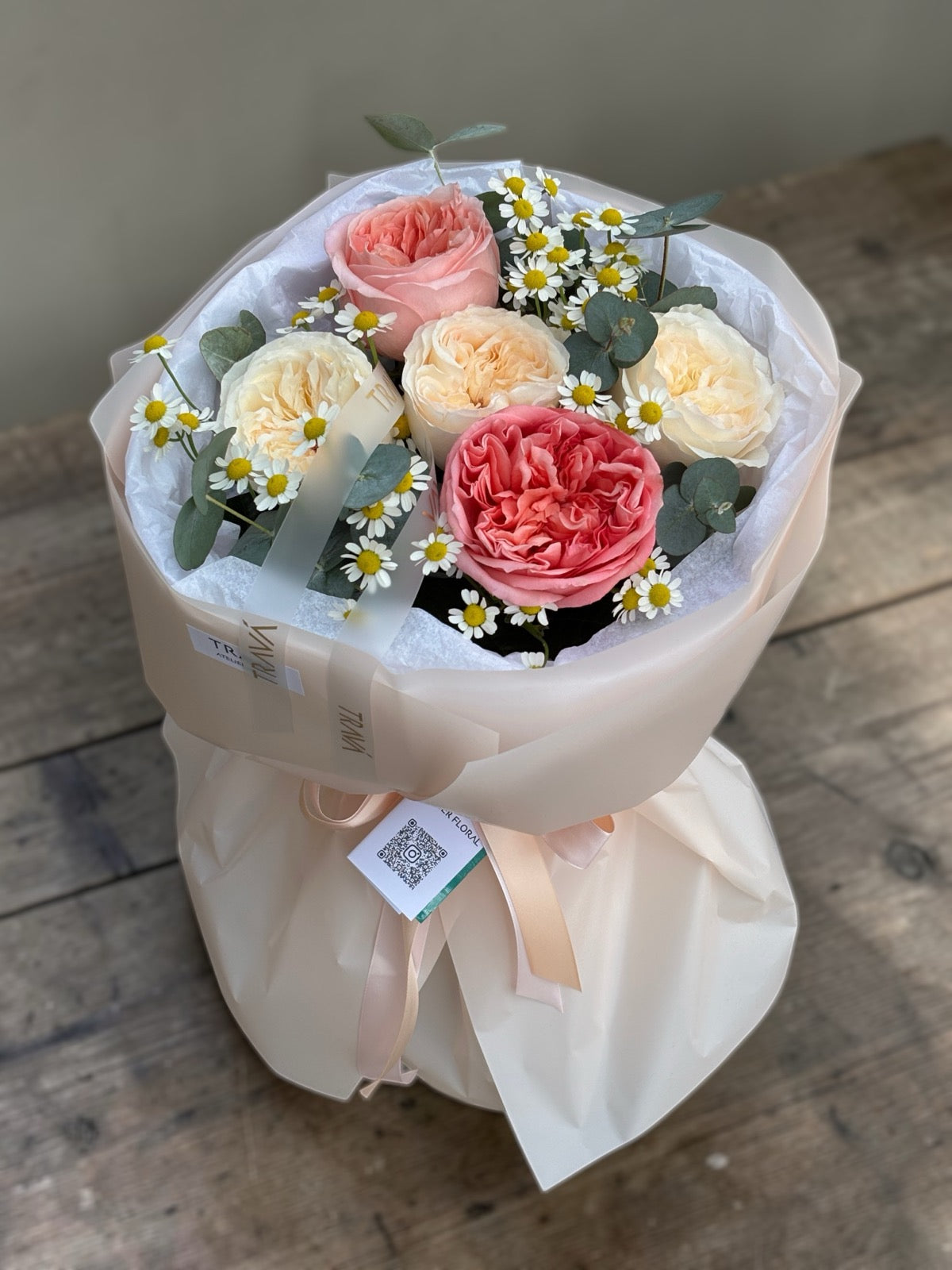 Buchet de primăvară cu trandafiri crem și roz, mușețel și eucalipt, ambalat în folie crem — livrare flori Oradea de la TRAVA Atelier Floral