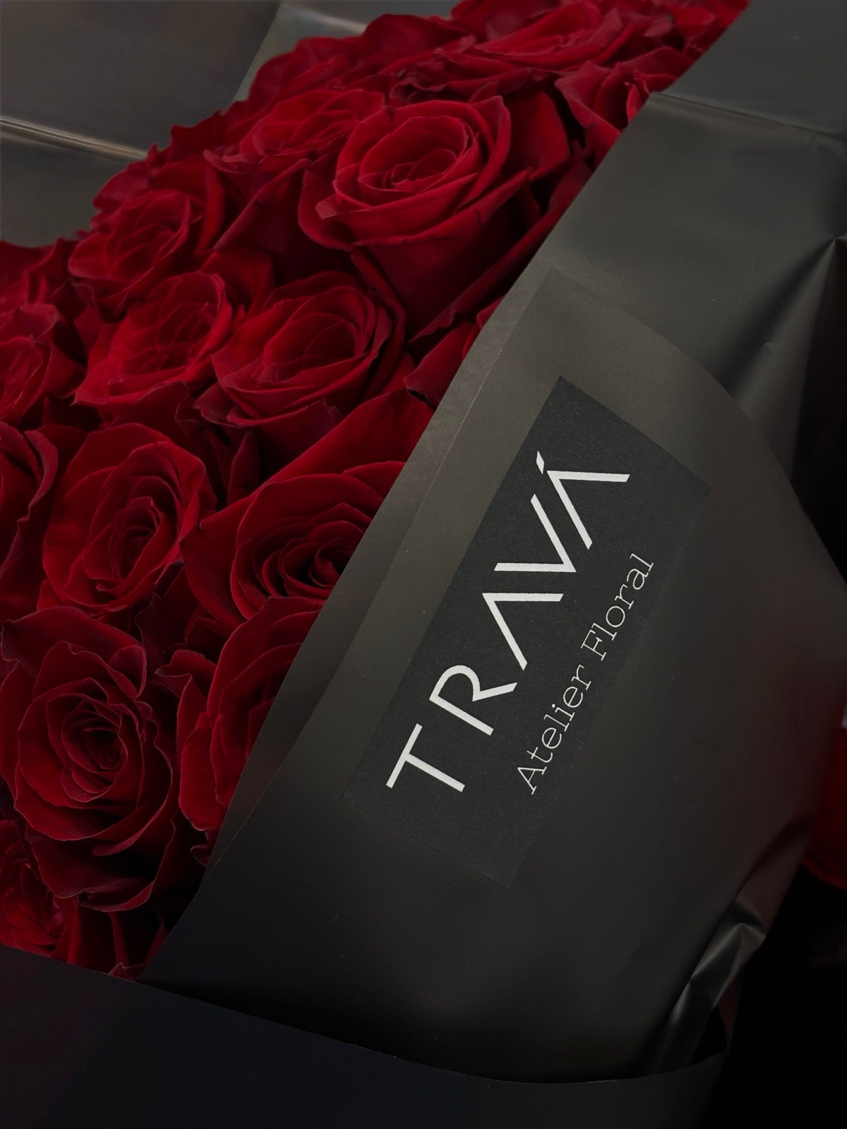 Buchet de 101 trandafiri roșii în ambalaj negru cu fundă roșie, disponibil la TRAVÁ florărie Oradea