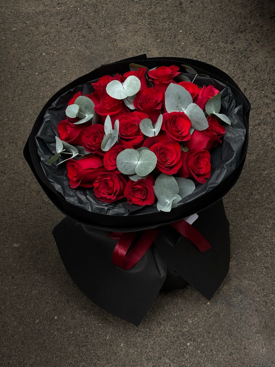 Buchet elegant de trandafiri roșii cu frunze de eucalipt în ambalaj negru – livrare flori Oradea