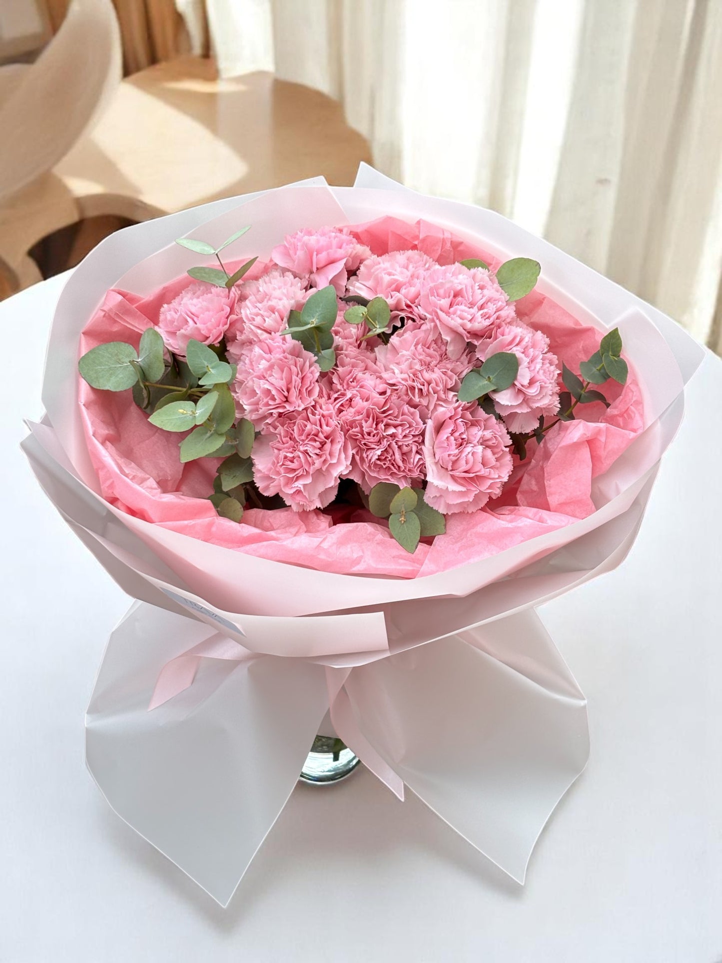 Buchet cu garoafe roz și eucalipt – flori proaspete cu livrare gratuită în Oradea de la florăria TRAVÁ Atelier Floral
