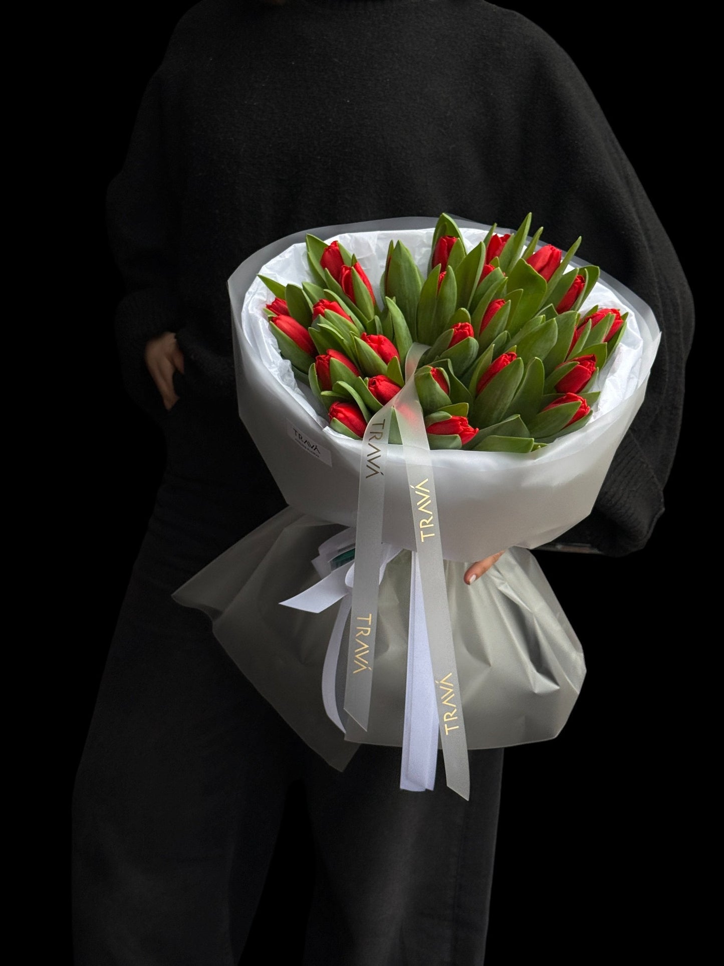 Buchet de lalele rosii in bratele unei femei. Florarie Oradea TRAVA Atelier, surpriza la domiciliu.