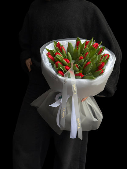 Buchet de lalele rosii in bratele unei femei. Florarie Oradea TRAVA Atelier, surpriza la domiciliu.