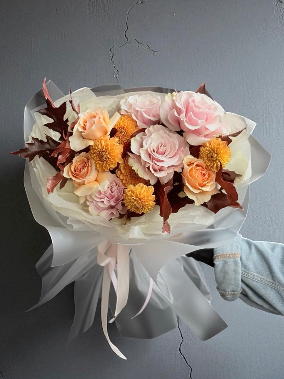 Buchet tomnatic cu trandafiri roz și portocalii, dalii și frunze de stejar, aranjat elegant și legat cu fundiță din satin.