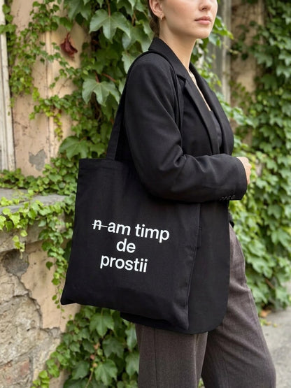 Sacosa din bumbac negru 100%, cu mesaj n-am timp de prostii, surprinsă în decor natural cu iederă.