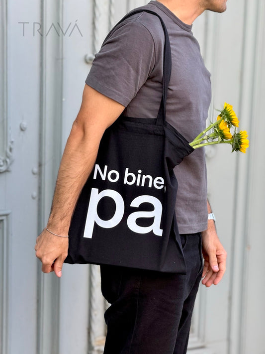 Torba neagră TRAVÁ din bumbac cu print alb pe față – mesaj amuzant ‘No bine pa’, purtată pe umăr.