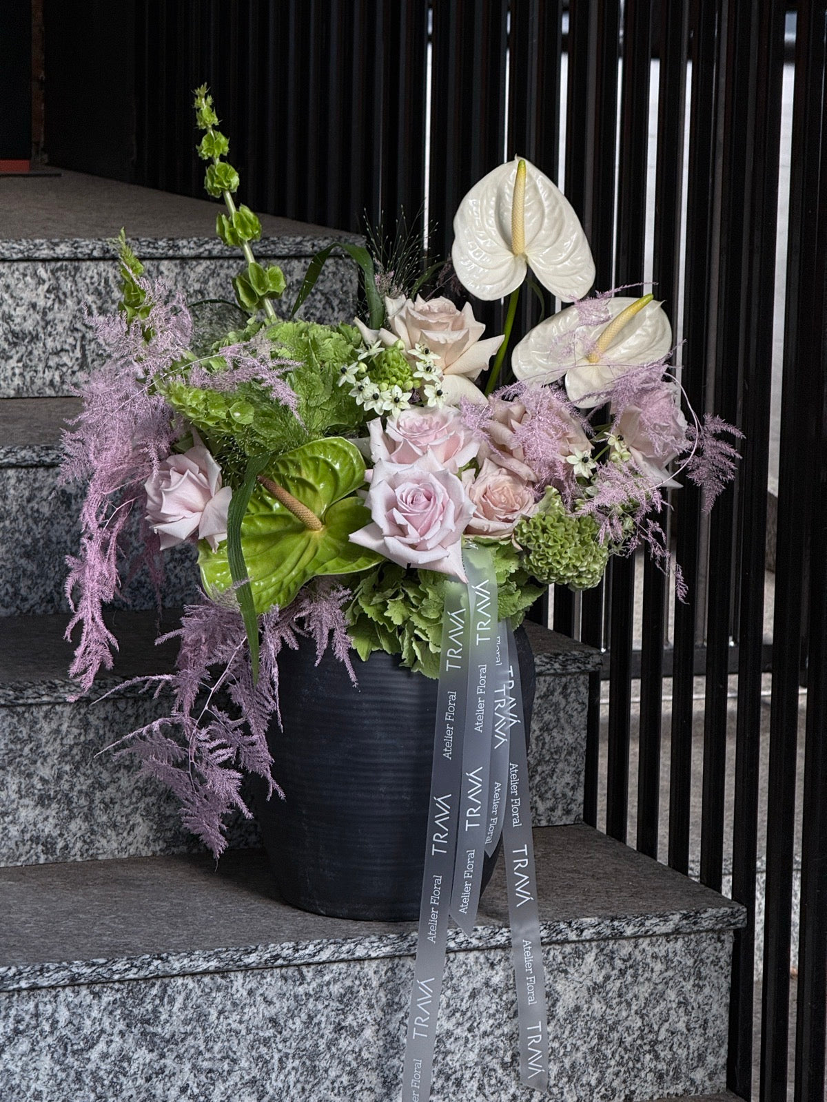 Aranjament floral elegant cu anthurium verde și alb, hortensii verzi și trandafiri roz pal, într-o vază modernă, livrare flori Oradea TRAVÁ.