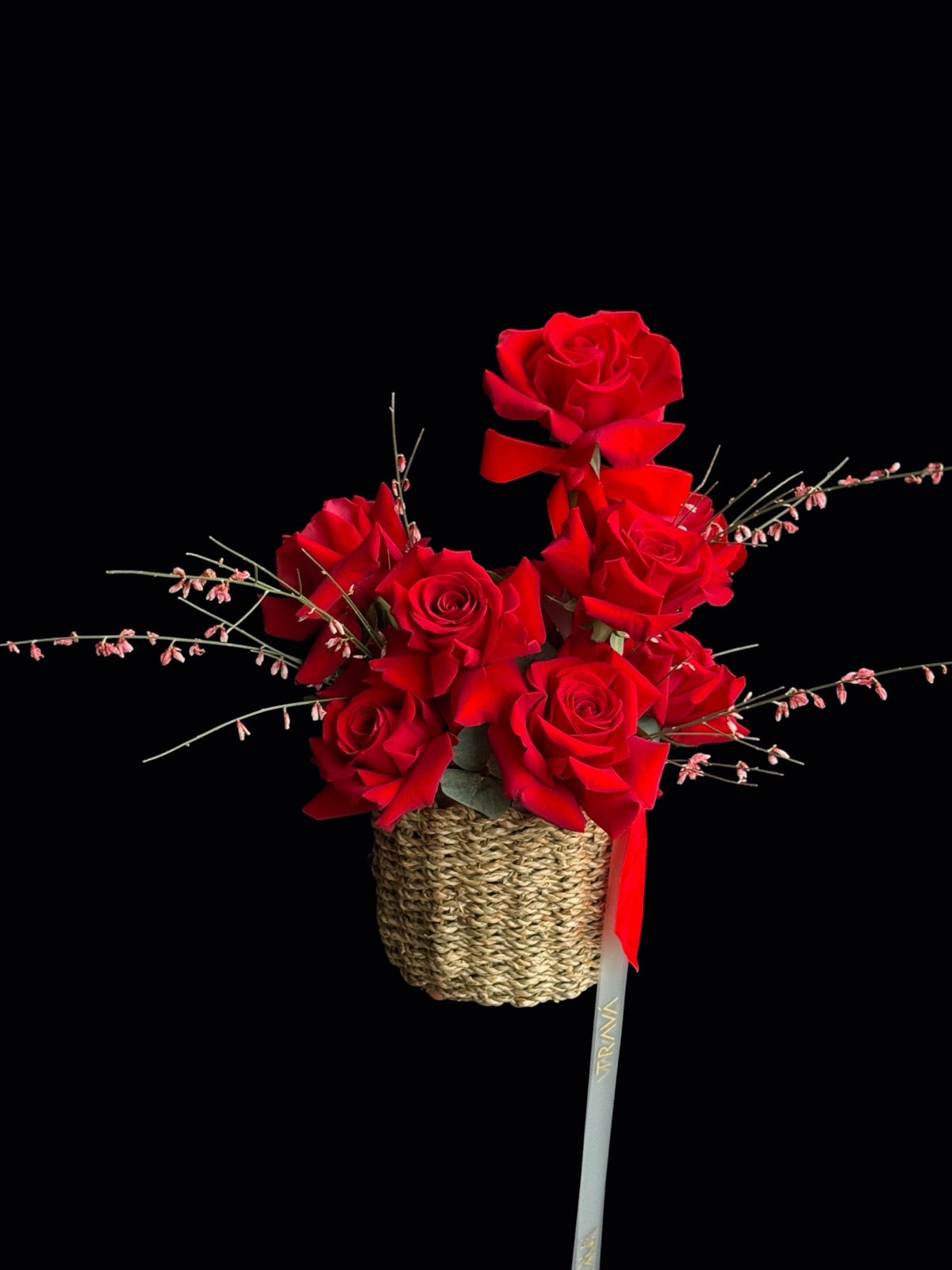 Aranjament floral cu trandafiri roșii și genista într-un coș natural, potrivit pentru cadou cu livrare în Oradea