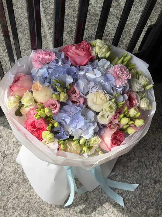 Buchet de flori cu hortensie albastră, trandafiri roz și lisianthus, realizat de florărie Oradea cu livrare gratuita