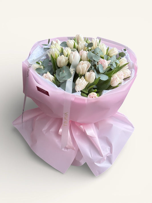 Buchet din lalele roz pal si frunze de eucalipt invelit in ambalaj roz disponibil cu livrare la domiciliu in Oradea.