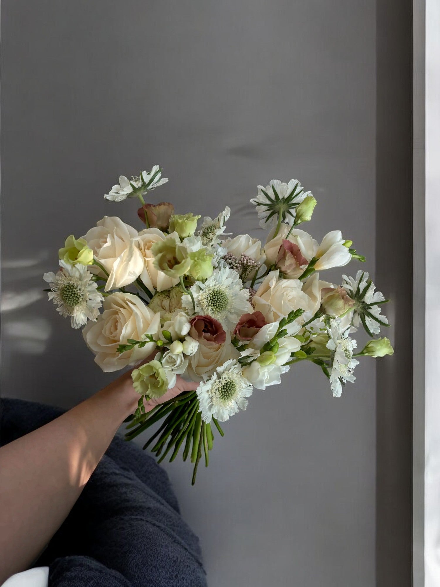 Buchet de mireasă răsfirat, elegant, realizat din scabiosa, trandafiri, frezii și lisianthus, perfect pentru o nuntă de vis. Aranjamentul floral adaugă un strop de frumusețe și rafinament zilei tale speciale.