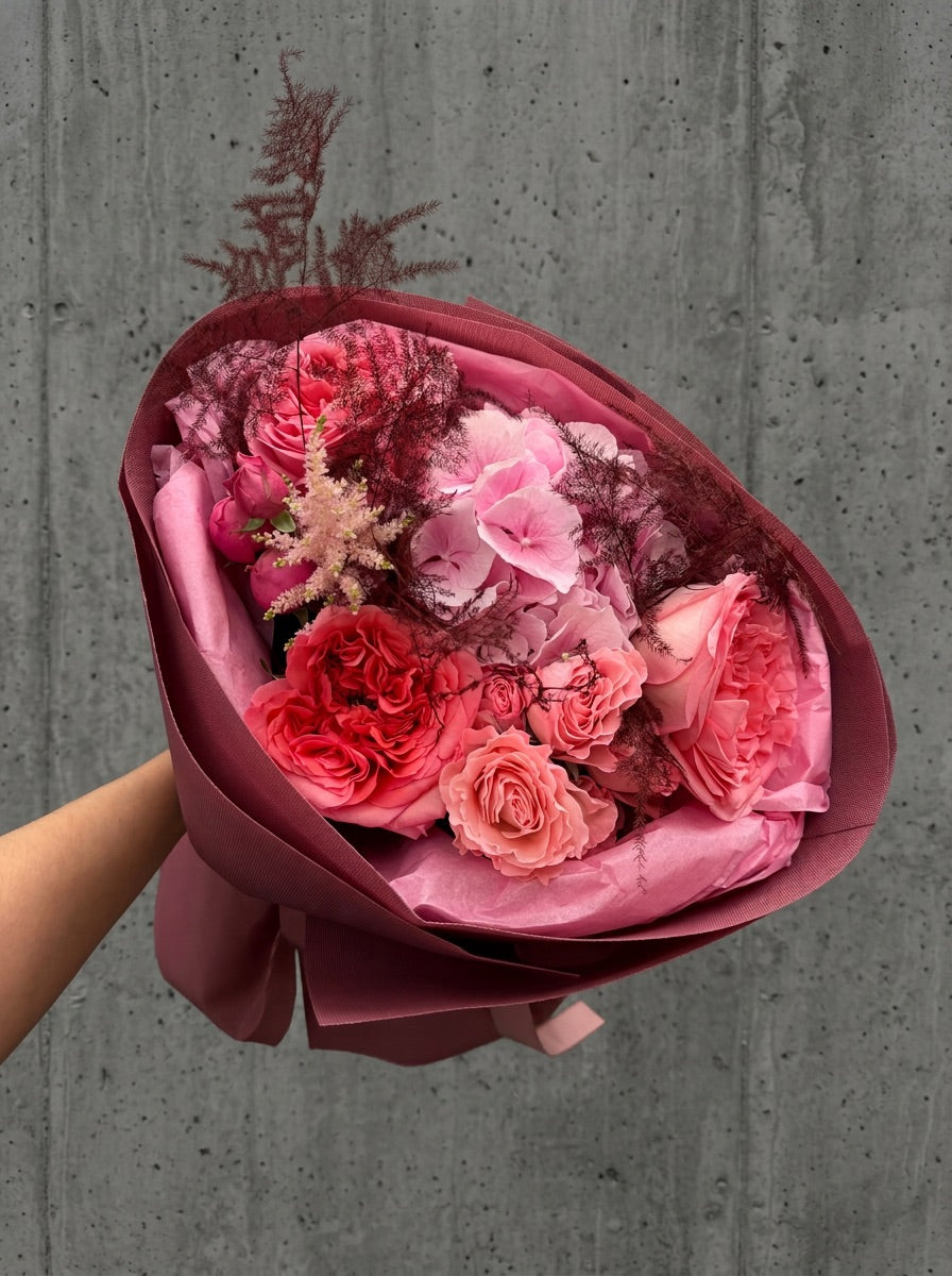Buchet de toamnă cu hortensie roz, trandafiri Pink Expression, trandafiri spray, astilbe și asparagus burgundy, în ambalaj burgundy – florărie Oradea