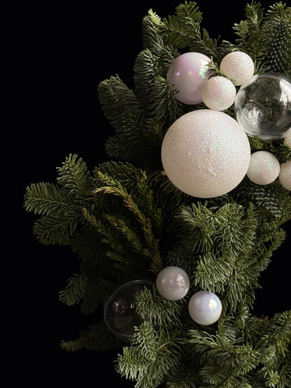 Prim-plan cu globuri albe și ramuri verzi din coronița de Crăciun Oradea - TRAVÁ